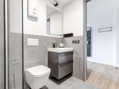 a bathroom with a toilet and a sink and a shower at Limehome Essen Kettwiger Straße in Essen