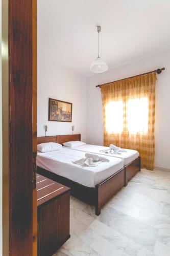 a bedroom with a large bed and a window at Villa Yianna in Néa Meságkala