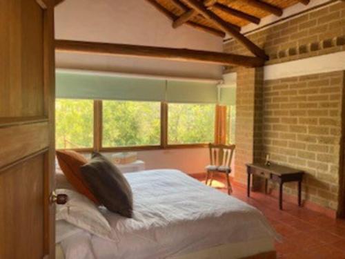 Un dormitorio con una cama y una pared de ladrillo. en Casa El Tambre, Villa de Leyva Boyaca, en Villa de Leyva