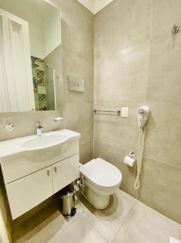a bathroom with a toilet and a sink and a phone at Hotel Chemin in Buenos Aires