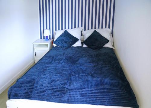 a bed with a blue comforter and two pillows at Sea Family in Dziwnówek