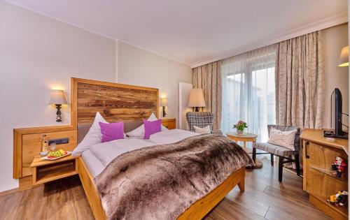 a bedroom with a large bed with purple pillows at Landhotel Schneider in Riedenburg