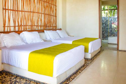 two beds sitting in a room with at Irekua Beach House Ixtapa in La Union de Isidoro Montes de Oca