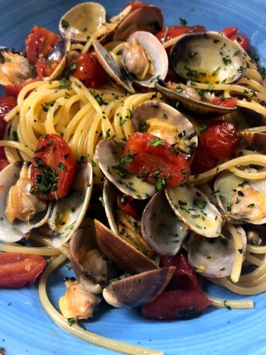 a blue plate of pasta with seafood and vegetables at Hotel Ristorante Cervo Malpensa in Case Nuove