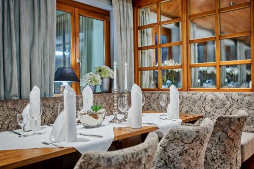 a dining room with a table and chairs and windows at Landhotel Schneider in Riedenburg