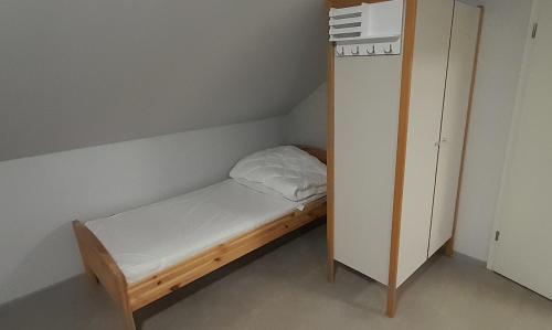 um pequeno quarto com uma pequena cama e um armário em Studio-Apartment Braunschweig in Wolfenbüttel em Volfembutel