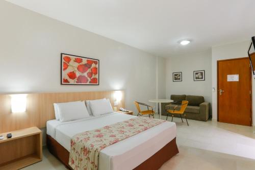 Habitación de hotel con cama y sala de estar. en HotSprings OFICIAL B3 Hotéis, en Caldas Novas