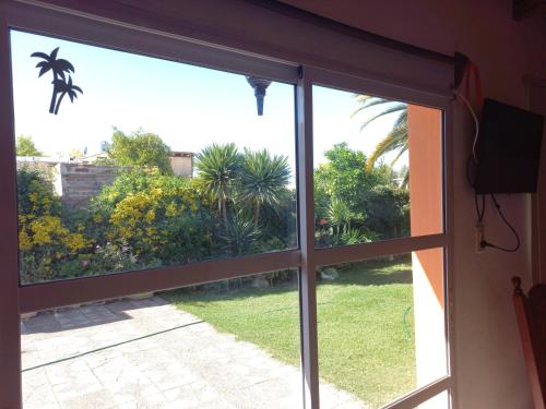 a sliding glass door with a view of a garden at LA PALMERA in Maipú