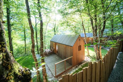 a wooden cabin in the woods with a wooden fence at Kamp Koren Kobarid in Kobarid