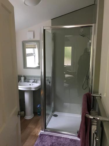 a bathroom with a shower and a sink at Kildinguie - Traditional Cottage - on NC 500 Route in Tongue