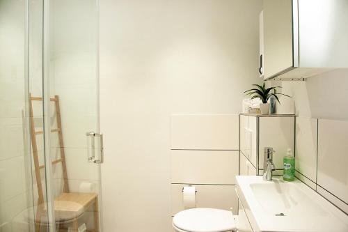 a white bathroom with a toilet and a sink at Fewo Ausspann in Stryck