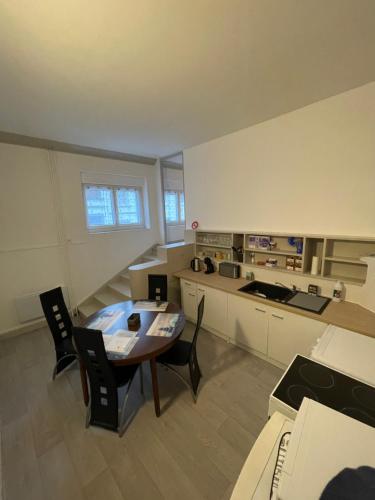- une cuisine avec une table et des chaises dans la chambre dans l'établissement Superbe appartement rénové au centre de Forbach, à Forbach