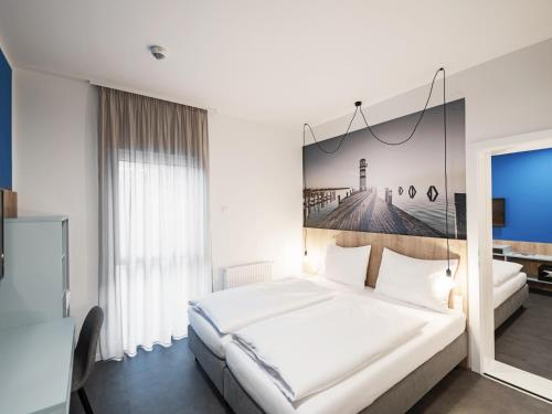 ein Schlafzimmer mit einem weißen Bett und einem Leuchtturm an der Wand in der Unterkunft Lakeside77 in Podersdorf am See