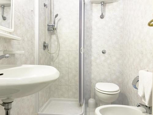 a bathroom with a shower and a sink and a toilet at Hotel Reginella in SantʼAgata sui Due Golfi