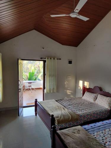 a bedroom with a bed and a ceiling fan at Creekside Cabin in Madikeri