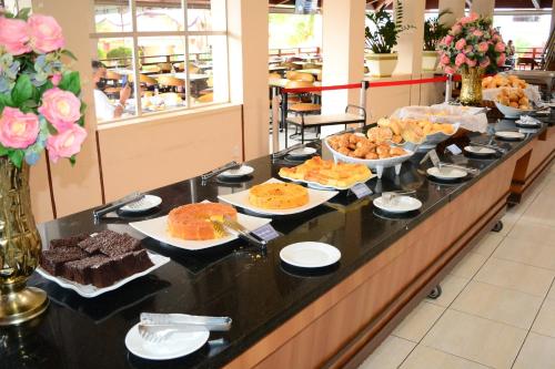 a buffet line with different types of cakes and pastries at HotSprings OFICIAL B3 Hotéis in Caldas Novas
