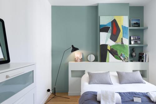 une chambre avec un lit et un tableau au mur dans l'établissement L'AUBELYNE - Chic T2 quartier préfecture, à Lyon