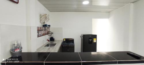 eine Küche mit einem schwarzen Herd und einem Kühlschrank in der Unterkunft Hermoso apartamento in Florencia