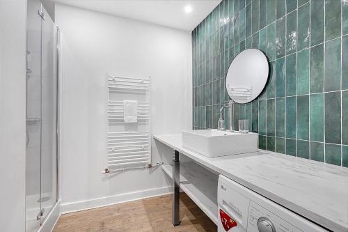 une salle de bain avec un lavabo et un miroir dans l'établissement L'APOLLINAIRE - à 5 minutes du centre ville, à Toulouse