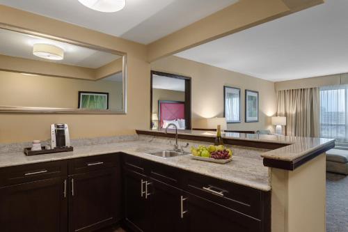 a kitchen with a sink with a bowl of fruit on the counter at Crowne Plaza Houston Galleria Area by IHG in Houston