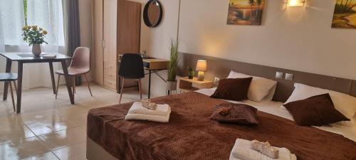 a bedroom with a large bed with two towels on it at Secret Garden Hotel in Maleme