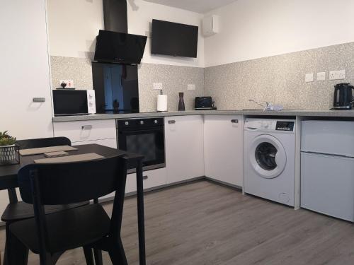 a kitchen with a washing machine and a washer at Eastcliff Escape Folkestone in Folkestone