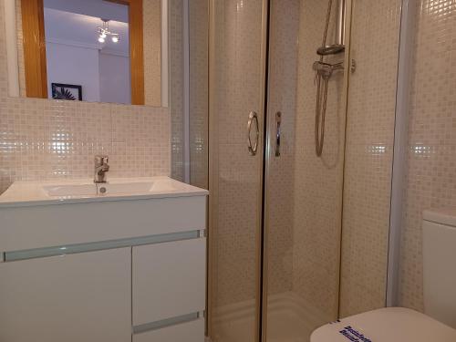 a bathroom with a shower and a sink and a toilet at APCOSTAS Marina D'or 2da Línea in Oropesa del Mar