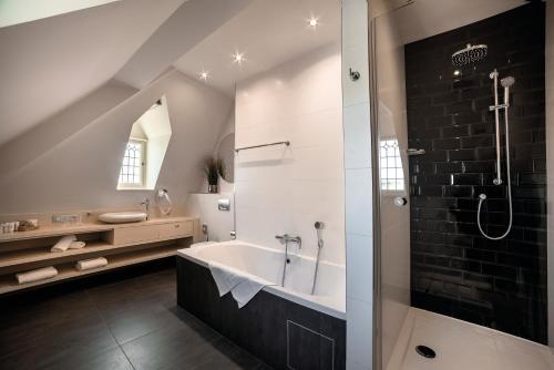 La salle de bains est pourvue d'une grande baignoire et d'un lavabo. dans l'établissement Van Der Valk Sélys Liège Hotel & Spa, à Liège