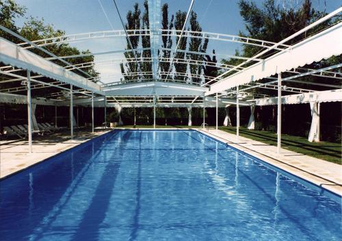 una piscina con dosel blanco y una piscina en Hotel Las Truchas, en Nuévalos