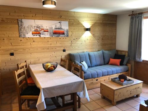 un salon avec un canapé bleu et une table dans l'établissement Balcons Appartements VTI, à Val Thorens