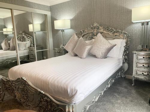 a bedroom with a large bed with white sheets and pillows at Ayrs and Graces - Luxury Bed and Breakfast in Ayr