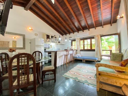 a kitchen and living room with a table and chairs at Casa Vento Norte in Ilhabela