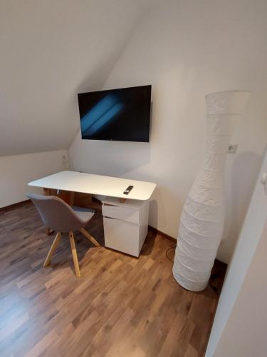 a white desk with a monitor and a desk with a chair at Businessapartments Klosterneuburg in Kritzendorf