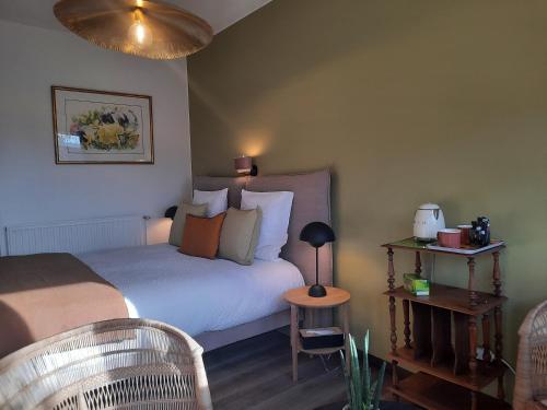 a bedroom with a bed and a table with a lamp at Au dela des vignes in Baubigny