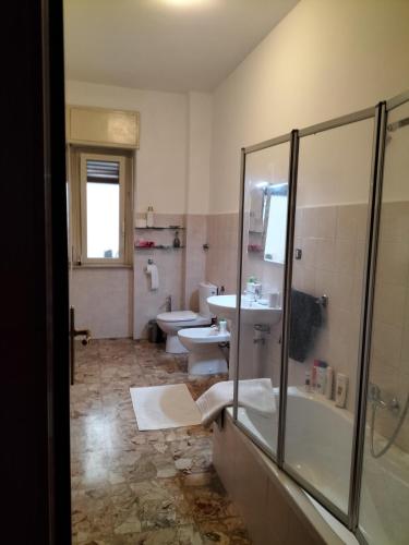 uma casa de banho com um chuveiro, um lavatório e um WC. em Casa del Grillo in centro e nei pressi del mare em Catânia