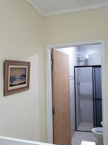 a bathroom with a shower and a toilet and a mirror at Mayda hostel in Praia Grande
