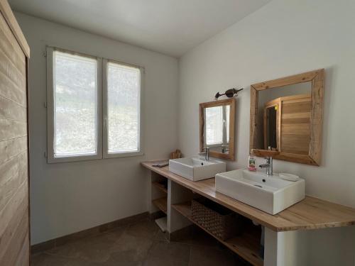 a bathroom with two sinks and a mirror at Estive des Angelettes Piscine chauffée Sauna in Saint-Ferréol-Trente-Pas