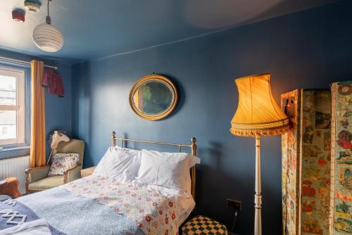 a blue bedroom with a bed and a lamp at La Rosa Hotel in Whitby