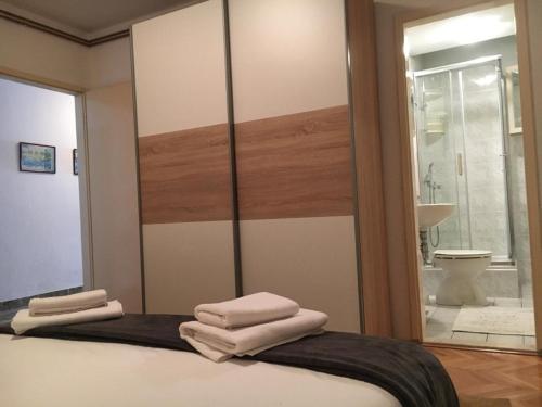 een slaapkamer met een spiegel met handdoeken op een bed bij Apartment Željko - large terrace in Makarska