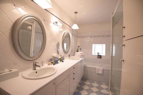 uma casa de banho branca com 2 lavatórios e um chuveiro em Chateau de Lantic em Martillac
