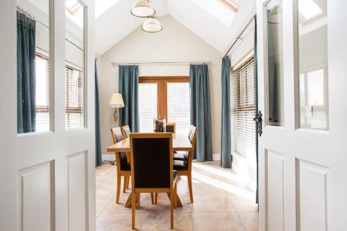 a dining room with a table and chairs and windows at Donegal Boardwalk Resort in Carrigart