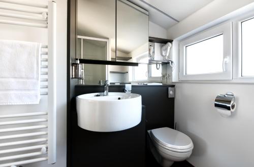a bathroom with a white sink and a toilet at Alpine House, NATUR RESORT in Kežmarok