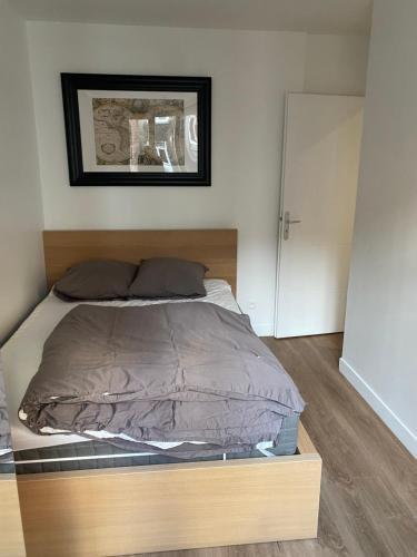 uma cama com uma estrutura de madeira num quarto em Appartement hypercentre 4 personnes 30 m2 em Lille