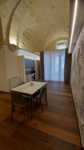 a dining room with a table and chairs in a room at Dimora Andrè - Monopoli Centro in Monopoli