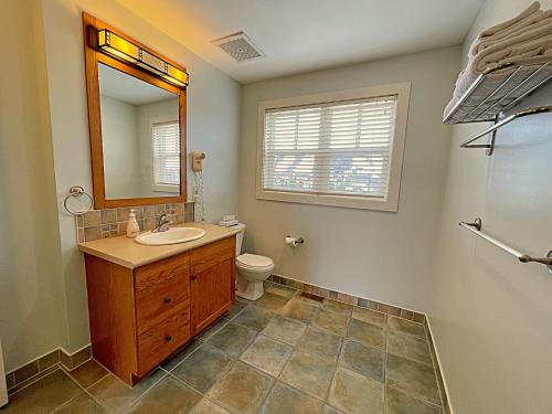 a bathroom with a sink and a toilet and a mirror at Spacious Blue Mountain 2 Storey - Wifi, Pool, Close to the Village & Golf in Blue Mountains