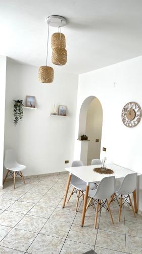 a dining room with a white table and chairs at La Casetta sul Golfo in Sferracavallo