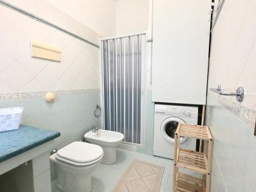 uma casa de banho com um WC e uma máquina de lavar roupa em La Casetta sul Golfo em Sferracavallo