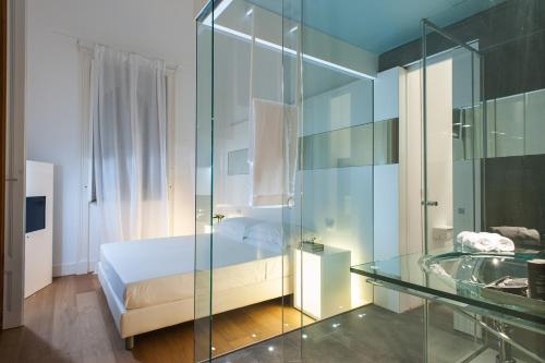 a bedroom with a bed and a glass shower at Zash Country Boutique hotel & SPA in Giarre