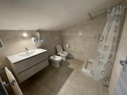 a bathroom with a sink and a toilet and a shower at Oceania apartments in Grosseto