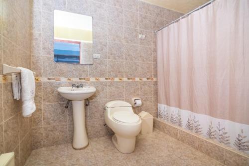 a bathroom with a toilet and a sink at Hotel Nativa in Chivay